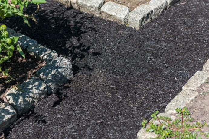 Recycled Rubber Walkway between stone borders of garden beds