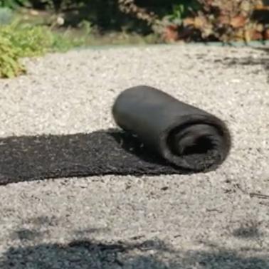 Recycled Rubber Walkway being rolled out over peastones