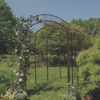 Jardin Meandering Arch set up between mulched garden beds with flowers growing up the side of the arch