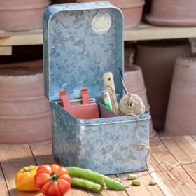 Womenswork Caddy packed with garden gloves and tools in front of garden bed