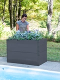 Woman tending to gray Putnam Metal Raised Bed 24" x 45" (30" D) by edge of pool