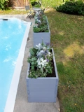 Light blue Putnam Metal Raised Bed 24" x 45" (30" D) shown in front of Putnam Metal Raised Bed 24" x 90" (30" D) planted up at edge of pool